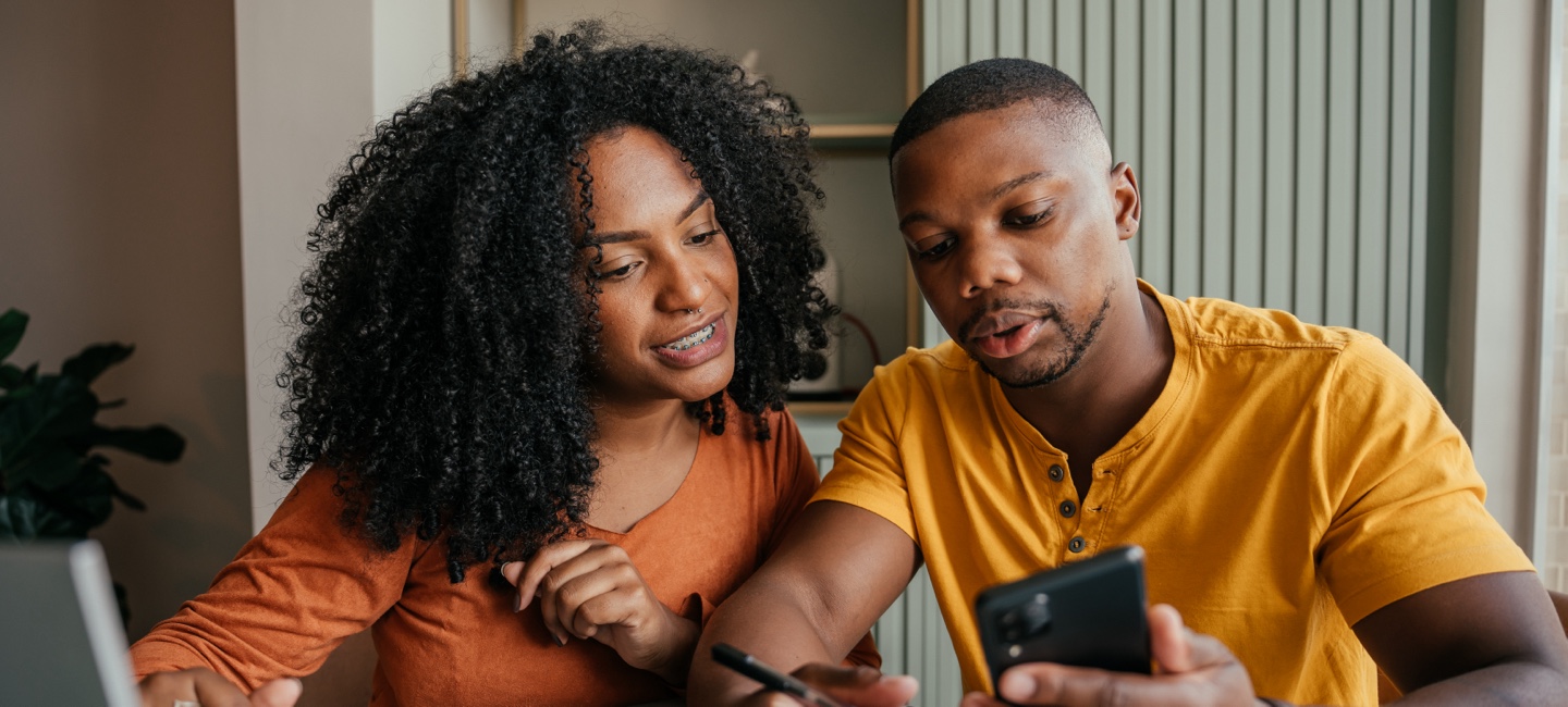 African-American couple looking at mobile phone