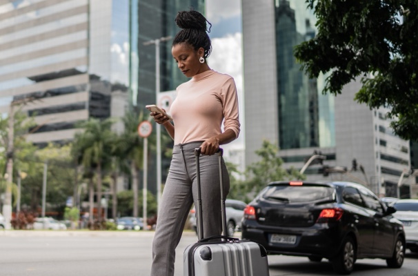 Female with luggage looking at mobile phone