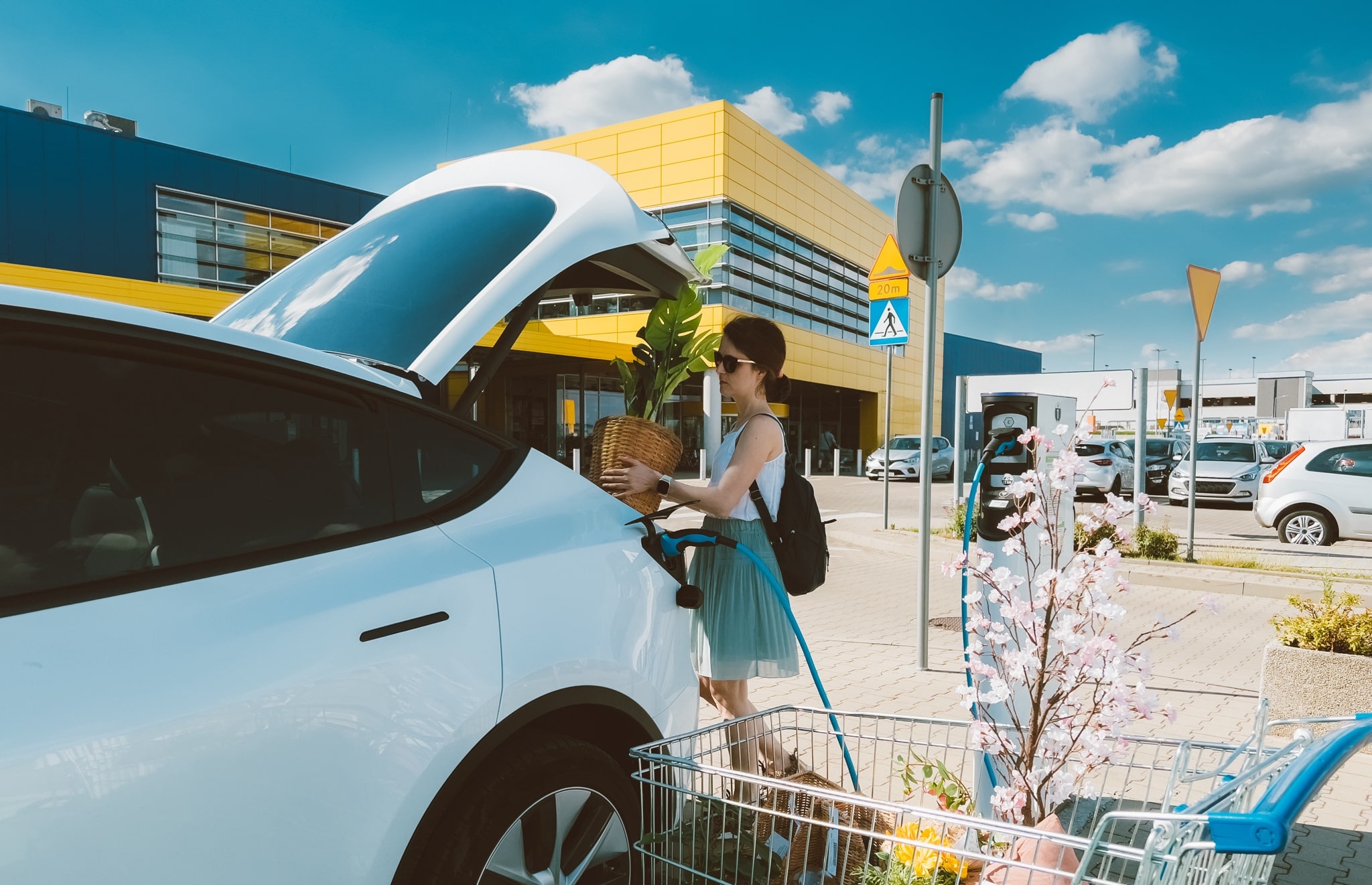 Woman charging and loading EV