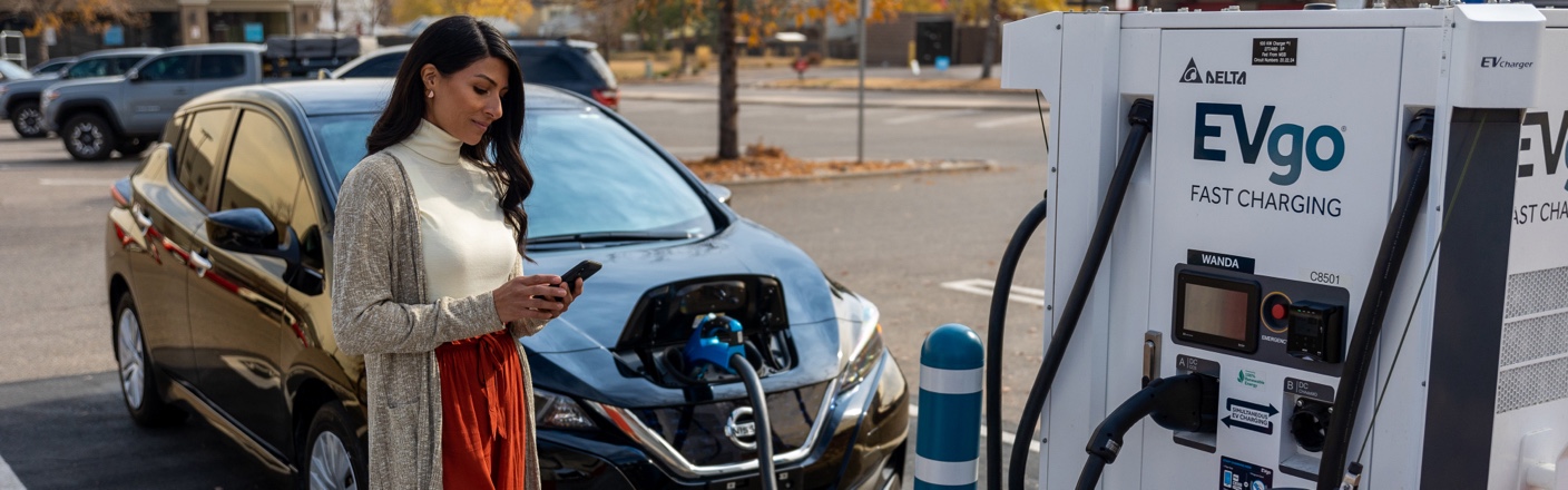 Woman chargine EV at EVgo Fast Charger